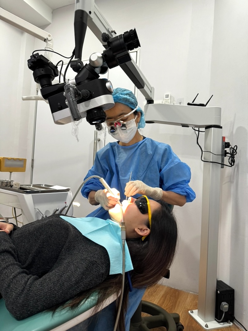 Dentist using the dental microscope for root canal treatment at WhiteZone Dental